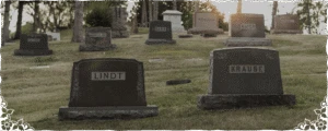 Cemetery With Multiple Headstones And Grave Markers On Grassy Hillside (1)